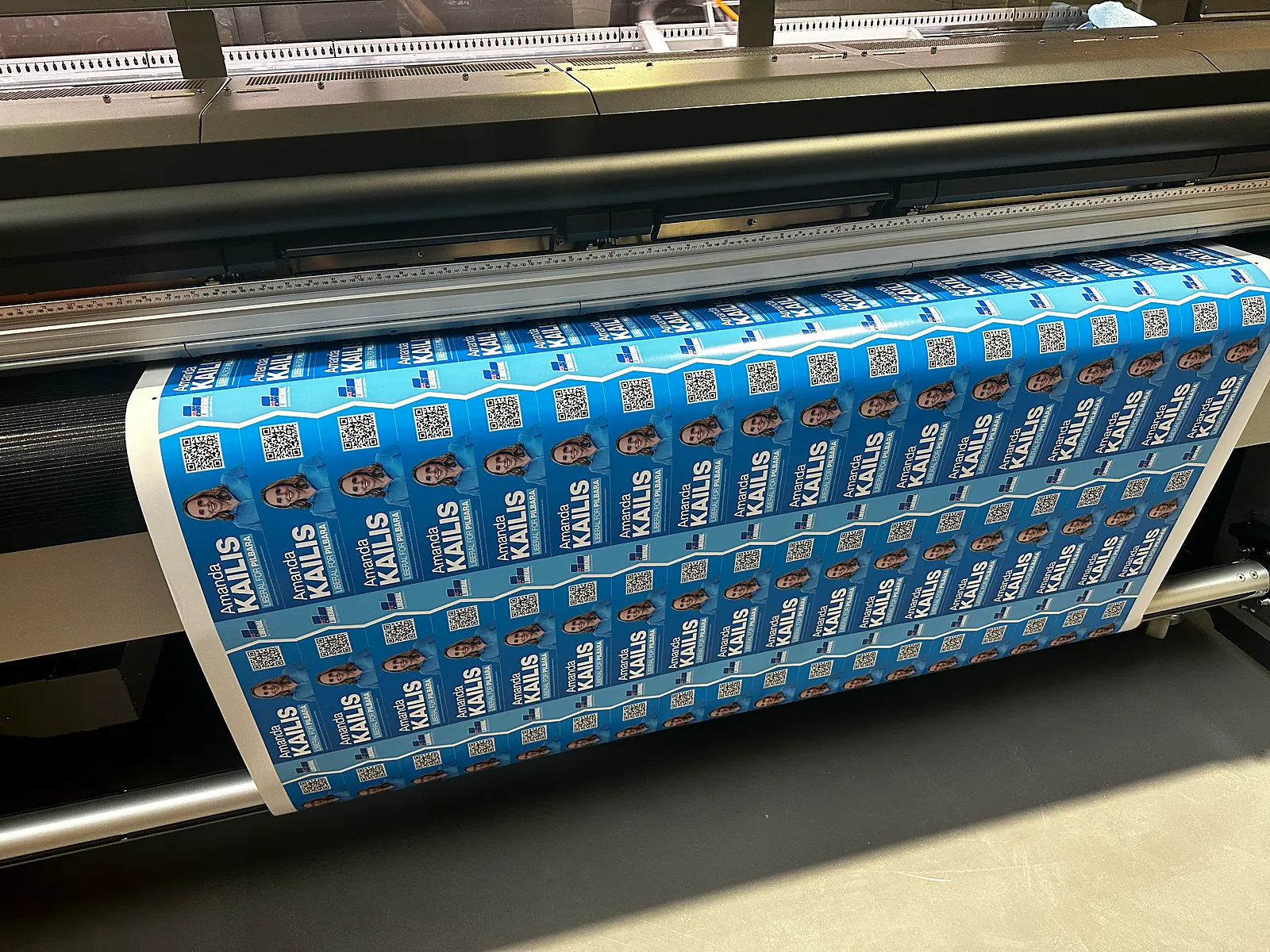 Roll-to-roll printer running a batch of election stickers at our Perth print shop